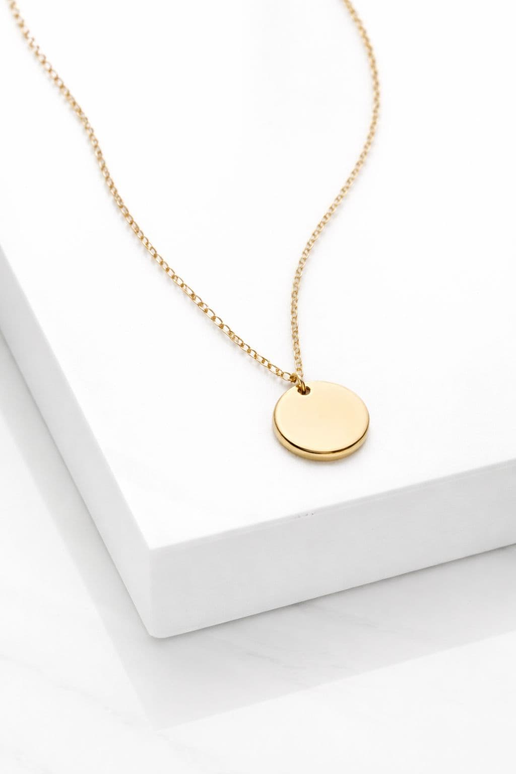 A small engraved gold pendant — close-up detail of a custom keepsake
